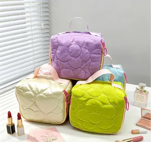 Stack of four colorful quilted makeup bags featuring heart and flower stitch patterns