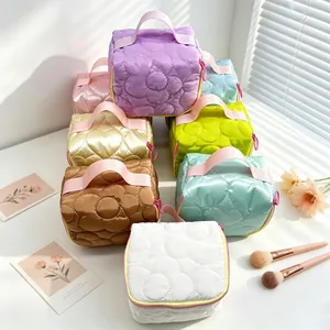 Set of colorful quilted makeup bags with floral patterns and top handles for travel storage.