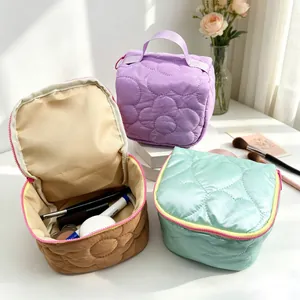 Detail view of quilted floral makeup bags showing soft texture and spacious interior