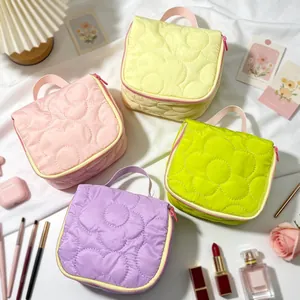 Detailed view of quilted floral makeup bags in four pastel colors with zip closure