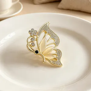 Elegant gold-tone butterfly brooch with opal wings and sparkling crystal accents