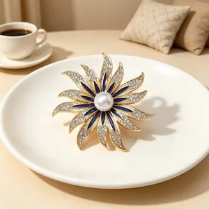Elegant starburst brooch with blue enamel, sparkling rhinestones, and center pearl