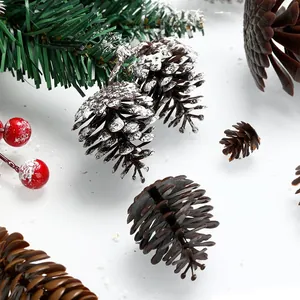 Primer plano detallado de piñas de plástico escarchadas y bayas rojas para manualidades navideñas