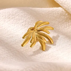 Vue macro détaillée d'une broche soleil en acier inoxydable doré avec fini mat.