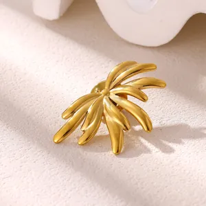Macro-photographie de détail d'une broche soleil en acier inoxydable plaqué or poli.