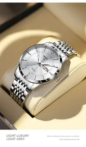 Nahaufnahme einer silbernen Herrenuhr mit weißem Zifferblatt und Datumsanzeige.