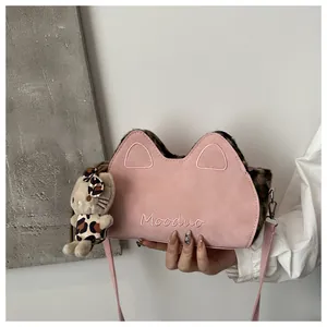 Gros plan du sac bandoulière rose oreilles de chat avec peluche léopard et charme.