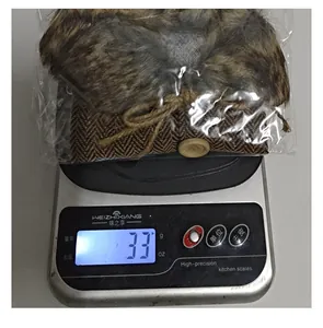 Gros plan montrant le poids de 33g du cache-bouteille de Noël en fausse fourrure