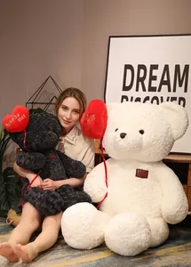 Large plush teddy bears holding red heart balloons, perfect for Valentine's Day gift.