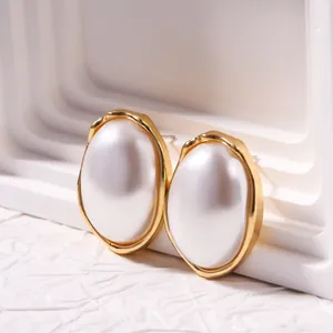Close-up of French vintage faux pearl stud earrings with textured gold-tone borders
