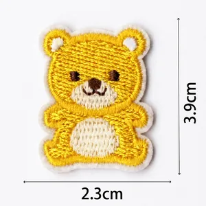 Vista detallada de un parche bordado de oso amarillo con medidas de 3,9 cm x 2,3 cm