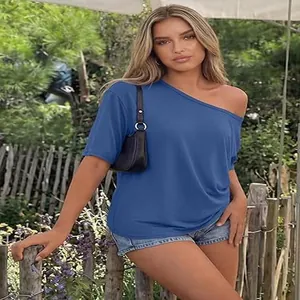 Stylish blue one-shoulder Y2K t-shirt for women shown in a rustic outdoor setting