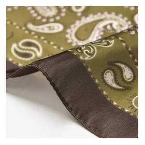 Close-up detail of vintage olive green paisley pattern silk scarf with dark brown hem.