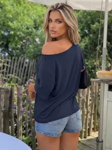 Elegant navy blue off-shoulder loose top for women shown from the back in a garden setting.