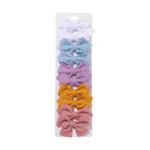 Detailed view of 10pcs waffle fabric bow hair clips in soft macaron colors on display card