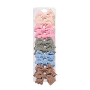 Detail view of five pairs of colorful macaron fabric bow hair clips on white card
