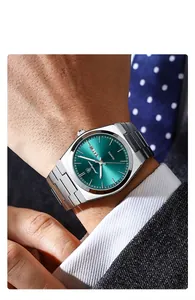 Primer plano de un reloj de cuarzo de lujo para hombre con esfera verde en la muñeca.