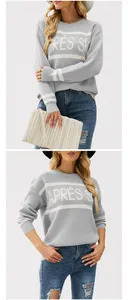 Dettaglio ravvicinato di un maglione grigio da donna con scritta jacquard APRÈS SKI e girocollo