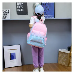 Little girl wearing a pink and blue gradient backpack with floral patterns back view