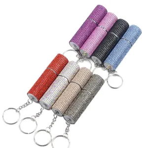 Detailed macro view of multi-colored rhinestone perfume spray bottles with metal keychains