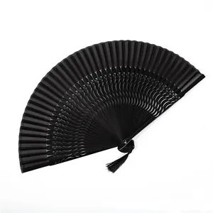 Detalle de elegante abanico plegable negro con borla tradicional y calados