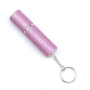 Close-up of sparkling pink rhinestone portable perfume atomizer with silver keychain attachment