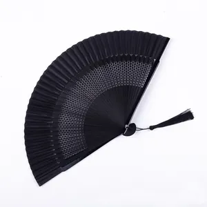 Vista detallada de un elegante abanico plegable lacado negro con patrones y borla