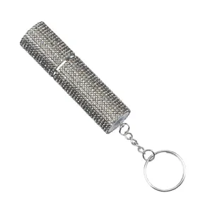 Detail view of a luxury silver rhinestone-encrusted perfume atomizer with keychain