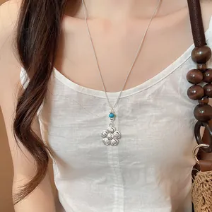 Collier minimaliste avec pendentif fleur argentée et perle bleue pour le quotidien