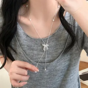 Elegante collana lariat regolabile in argento con fiocco e perle delicate su modella