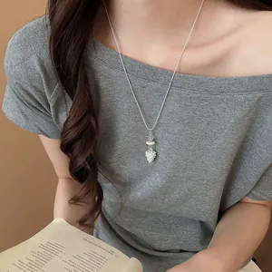 Collana lunga in argento minimalista con ciondolo a goccia testurizzato su modella