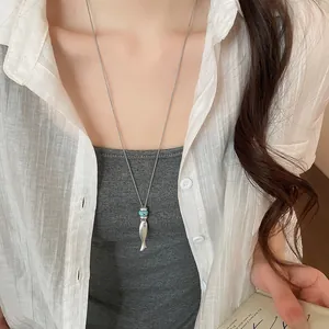 Lunga collana minimalista in argento con pendente a pesce e dettaglio perla turchese