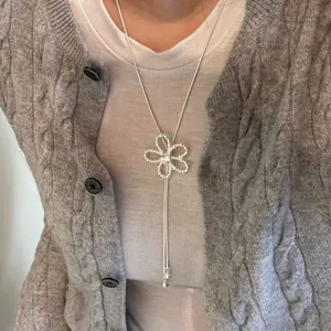 Collana a Y in argento regolabile con pendente a fiore cavo su modella.