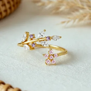 Gros plan détaillé d'une bague ajustable avec motif de feuille et fleur et cristaux roses