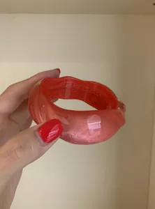 Close-up of colorful translucent resin bangle with wavy design and pearlescent finish