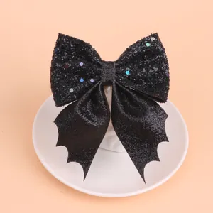 Primer plano de un lazo para el pelo con purpurina negra brillante y alas de murciélago para Halloween