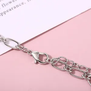 Close-up view of a silver lobster clasp and metal chain on a pink background
