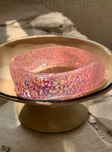 Close-up of pink translucent resin bangle with colorful iridescent stars