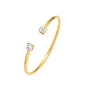 Elegante bracciale rigido aperto in acciaio al titanio placcato oro con due zirconi tondi