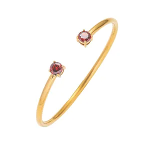 Bracciale rigido aperto in acciaio dorato con due zirconi rotondi rossi