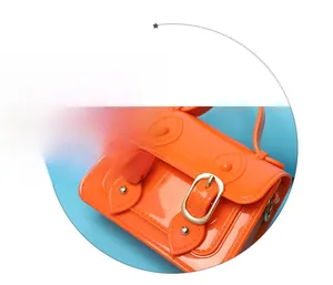Detailed view of a vibrant orange mini jelly Cambridge bag with shiny gold-tone buckles.
