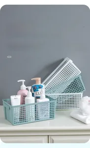 Macro view of rectangular mesh storage baskets organizing toiletries in a bathroom