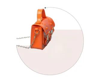 Side view detail of bright orange jelly mini Cambridge bag with silver chain strap
