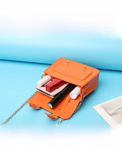 Close-up view showing the internal capacity of an orange jelly mini bag with chain strap