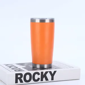 Leuchtend oranger 20oz vakuumisolierter Edelstahlbecher auf einem modernen weißen Buch