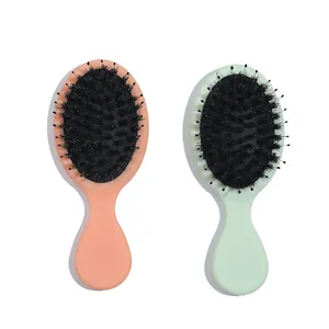 Primer plano de cepillos de masaje de cerdas de jabalí en color rosa y verde.