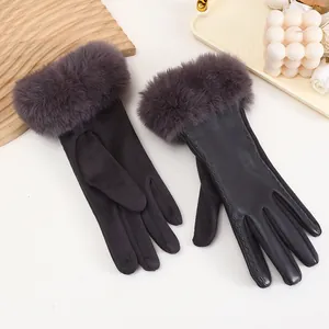 Detail of grey suede and PU leather gloves with faux fur cuffs on a decorative tray