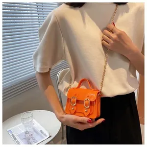 Mini orange jelly Cambridge bag with gold chain strap for summer fashion crossbody wear.