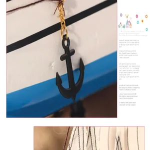 Detail view of a Mediterranean wooden sailboat decor with anchor charm and canvas sails.