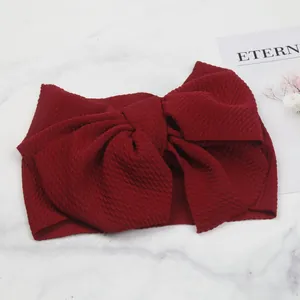 Detailed texture of a burgundy bubble fabric baby headband with a large bow